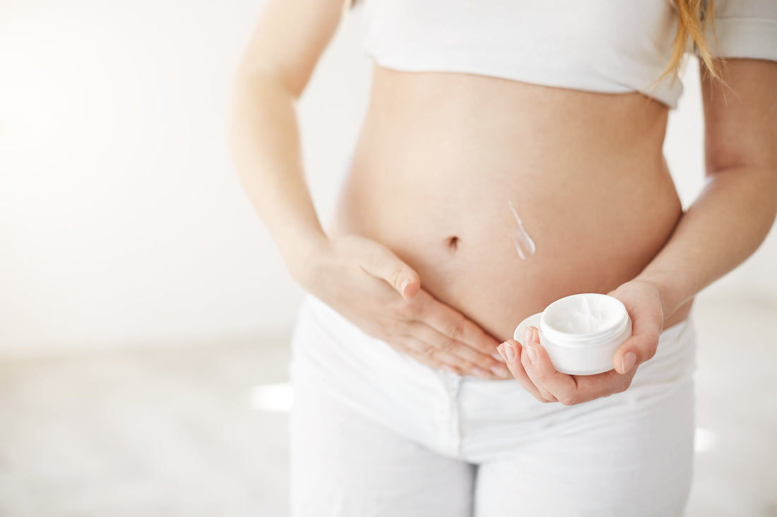 lady moisturising her pregnancy bump